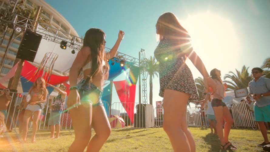 Dos chicas bailan en una fiesta en la playa. ARCHIVO