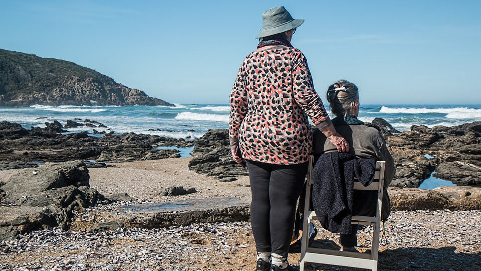Dos ancianas contemplan el mar en una playa
