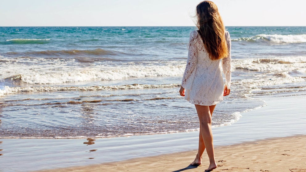Una chica disfruta en la arena junto al mar