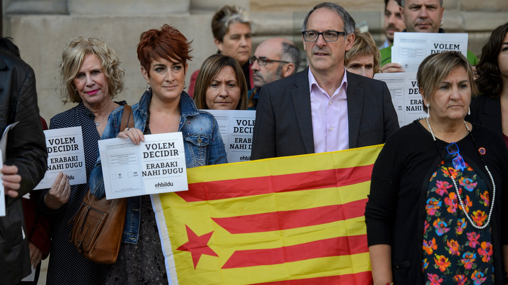 Los parlamentarios Barkartxo Ruiz y Adolfo Araiz, de EH Bildu, sostienen una estelada y carteles en apoyo al referéndum catalán. PABLO LASAOSA