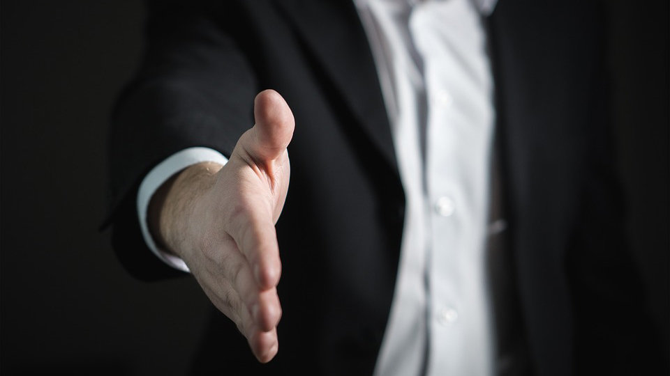 Un empresario tiende la mano en señal de acuerdo con su interlocutor ARCHIVO