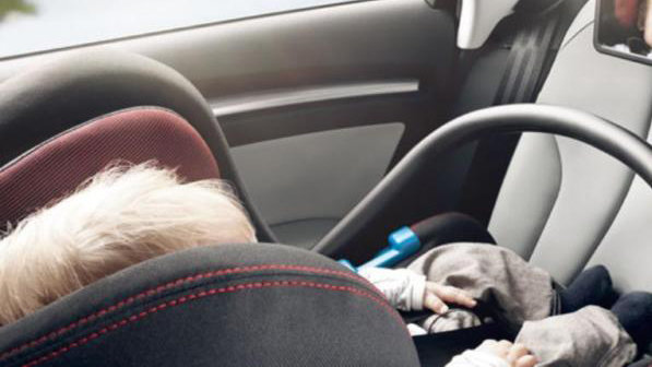 Imagen de un niño durmiendo en un el asiento de seguridad para menores dentro de un coche ARCHIVO 2