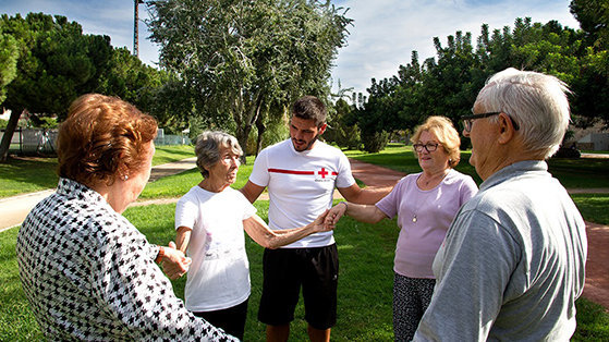Un joven realiza actividades al aire libre con un grupo de personas mayores