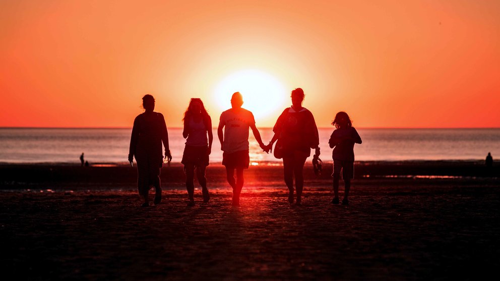 Una familia camina por una playa