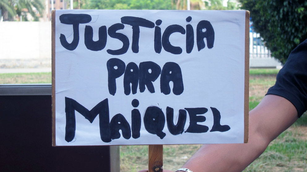 Una persona sujeta un cartel pidiendo justicia para el joven asesinado.