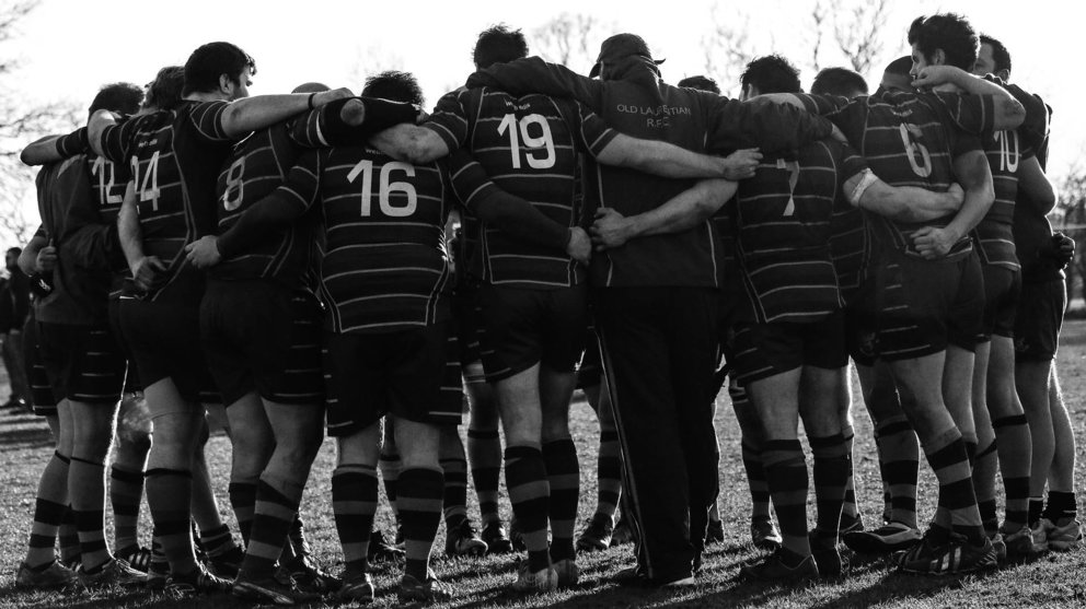 Un equipo de rugby se abraza durante un partido.