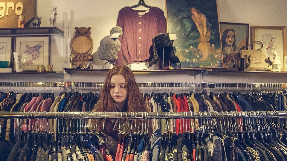 Una mujer mira ropa en una tienda comercio