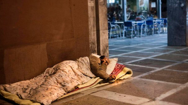 Un hombre sin techo duerme en plena calle cubierto con varias mantas EFE
