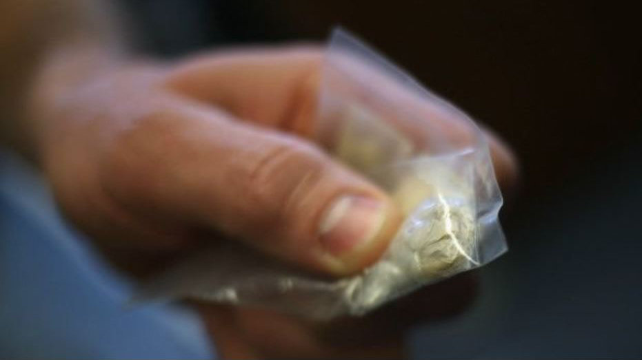 Imagen de un joven sosteniendo una bolsa con droga en su interior ARCHIVO