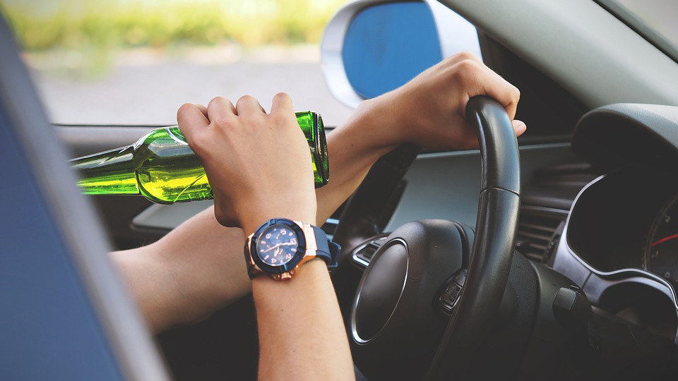Imagen de una persona tomando una cerveza mientras conduce un coche ARCHIVO