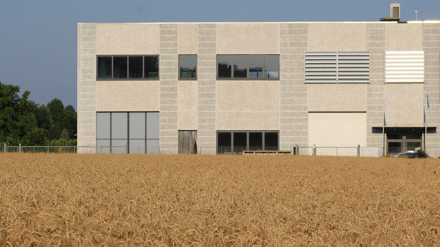 Imagen de archivo de la fachada de una empresa y un campo de trigo situado en sus inmediaciones ARCHIVO
