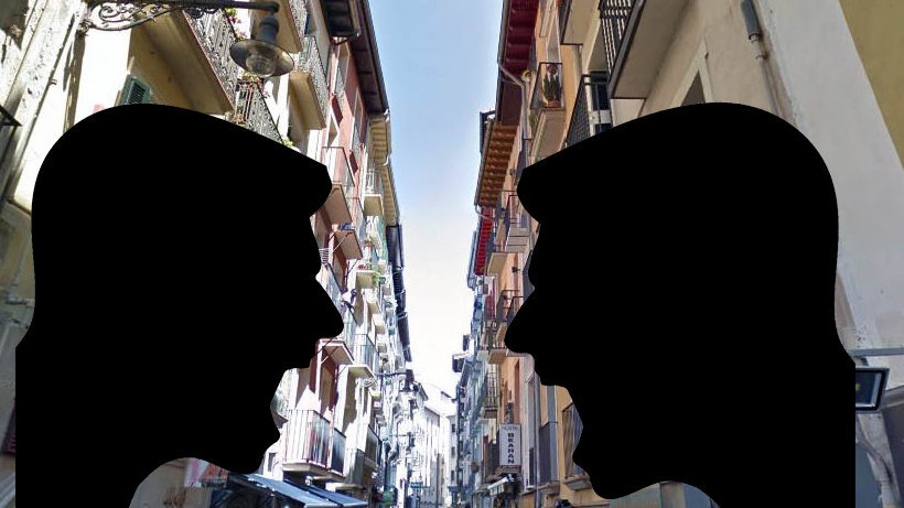 Dos personas discuten sobre el fondo de la calle San Nicolás de Pamplona.