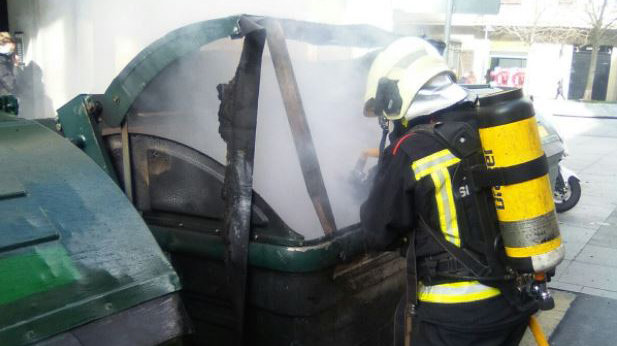 Un bombero sofoca el fuego en un contenedor de Pamplona que se ha incendiado BOMBEROS DE NAVARRA