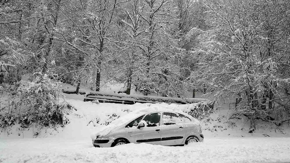 Un coche permanece atascado en la nieve en el Alto de Mezquiriz donde, tras el último temporal de nieve, frío y viento, se han llegado a acumular espesores de hasta 30 cm y mantiene a toda la comunidad Foral en alerta por nieve. EFE/Villar López