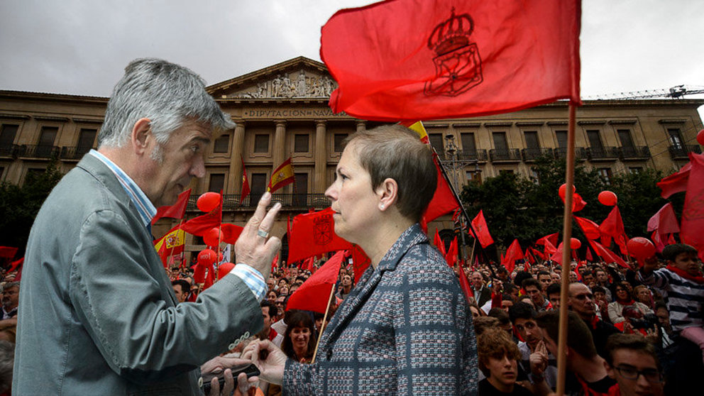 Koldo Martínez y Uxue Barkos, de Geroa Bai, junto a una imagen de la marcha en defensa de la bandera de Navarra celebrada en 2017 NAVARRACOM