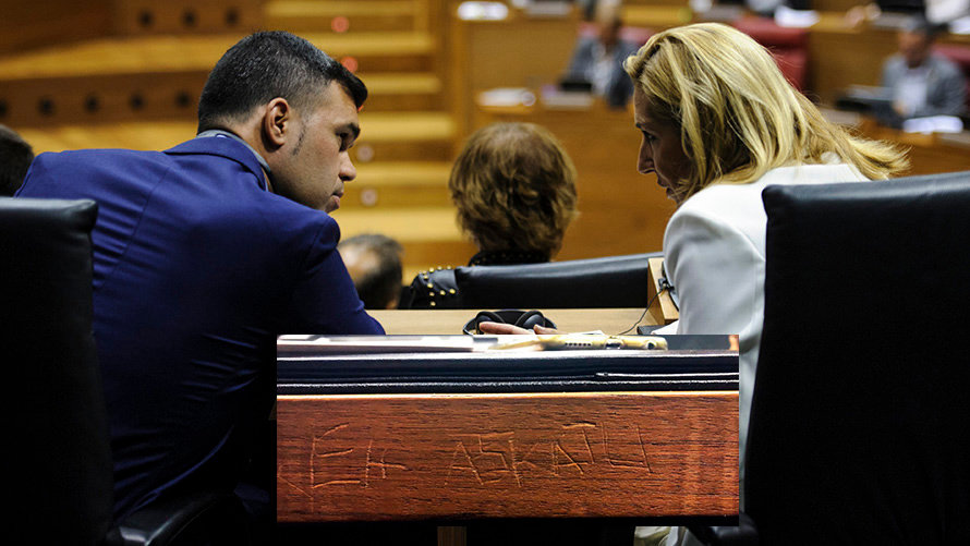 Javier García y Ana Beltrán (PP) charlan durante el pleno del parlamento. Sobreimpresionado se puede ver la inscripción. MIGUEL OSÉS