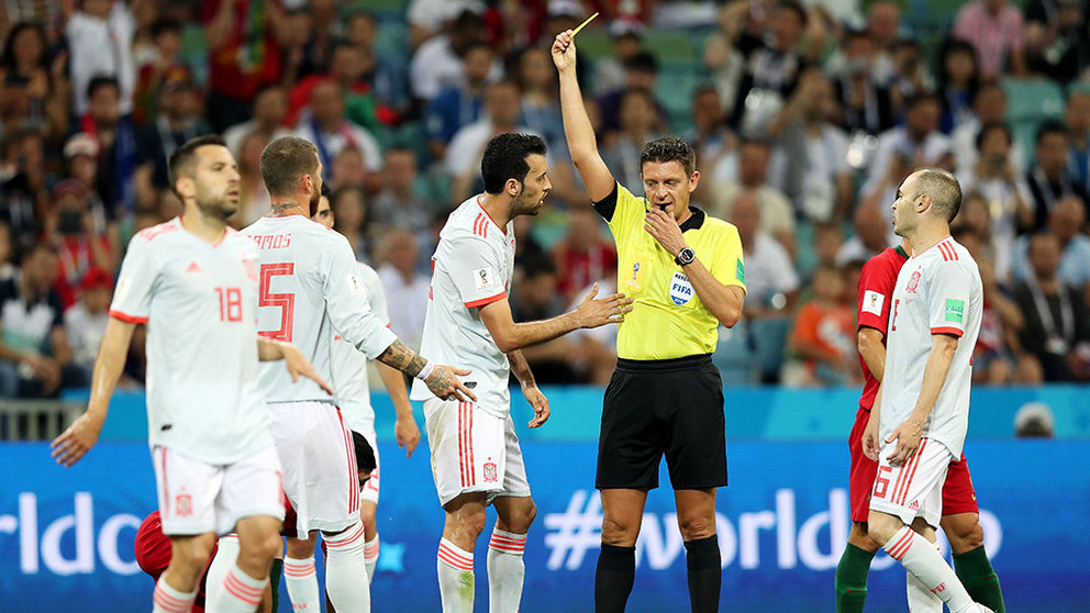 Sochi (Russian Federation), 15/06/2018.- Referee Gianluca Rocchi shows Sergio Busquets (center L) of Spain the yellow card during the FIFA World Cup 2018 group B preliminary round soccer match between Portugal and Spain in Sochi, Russia, 15 June 2018.