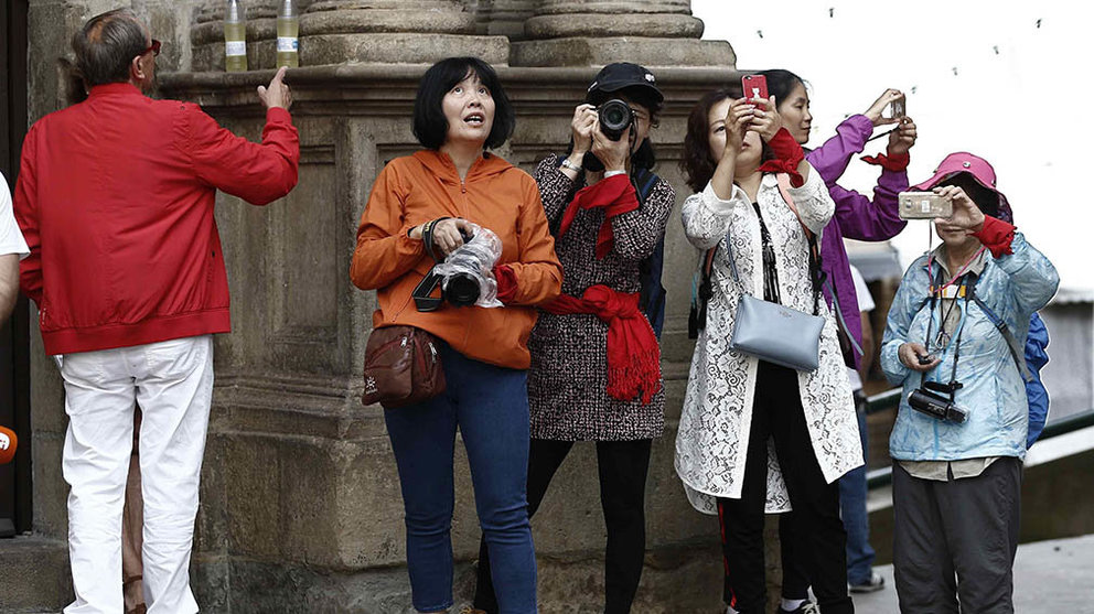 Un grupo de turistas orientales toman fotografías en la Plaza del Ayuntamiento de Pamplona, donde trendrá lugar el tradicional &#34;txupinazo&#34; desde el balcón de la casa consistorial con el que dará comienzo oficialmenta las fiestas de San Fermín 2018. EFE/Jesús Diges
