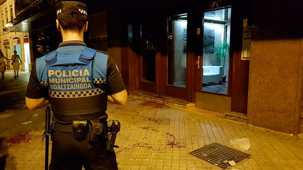 Un Policía Municipal contempla el cristal roto y un reguero de sangre. POLICÍA MUNICIPAL