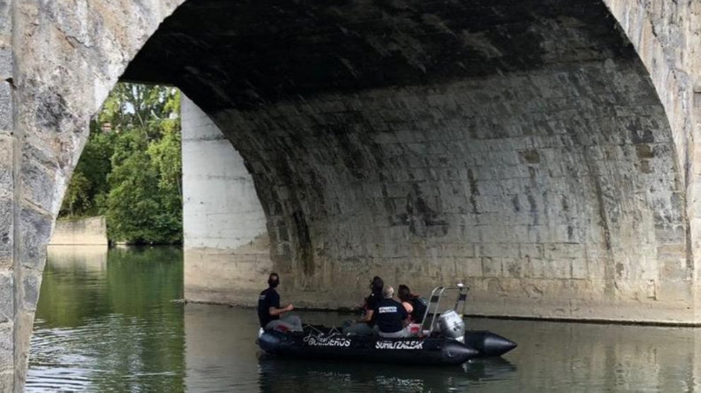 El grupo de rescate acuático de los bomberos realiza maniobras con buzos y lanchas en el río Arga a su paso por el puente de Cuatrovientos, en Pamplona. BOMBEROS DE NAVARRA