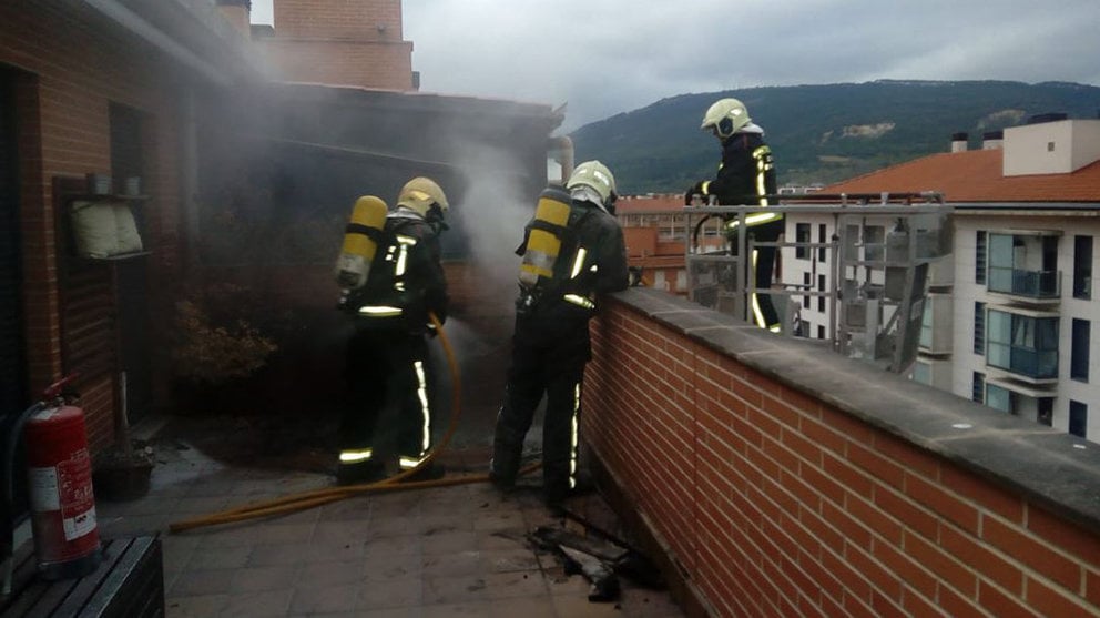 Los bomberos sofocan el incendio originado en una maceta de la terraza de un ático en un bloque de pisos del barrio de San Jorge, en Pamplona. BOMBEROS DE NAVARRA
