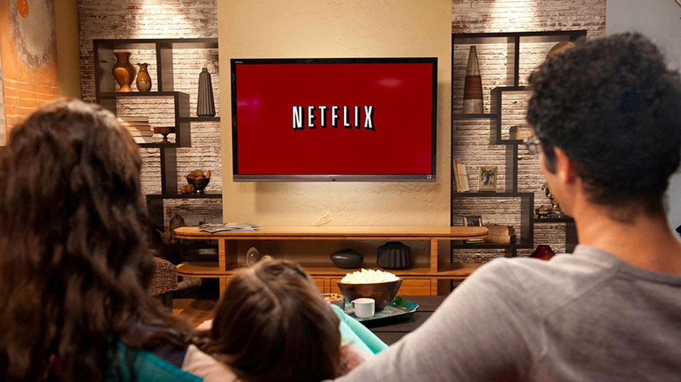 Una familia sentada en el sofá se dispone a ver una serie de televisión en Netflix ARCHIVO