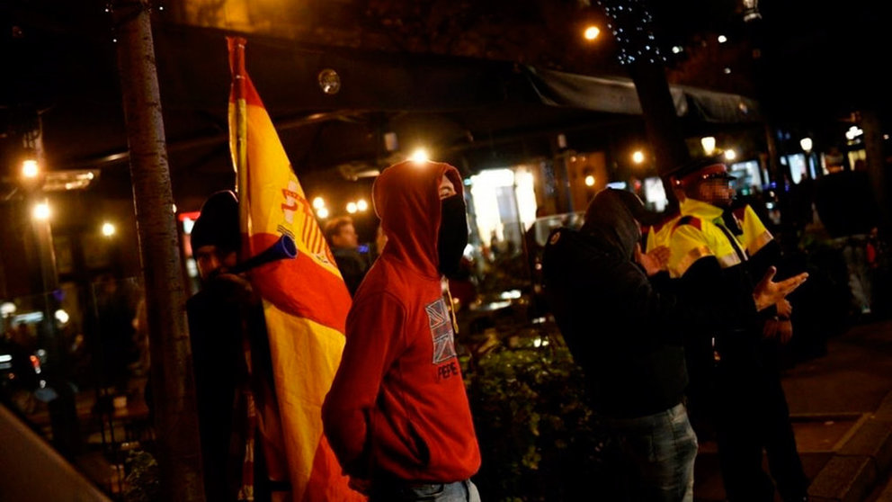 Varios de los jóvenes que han entrado al acto portando banderas y gritando viva España. TWITTER