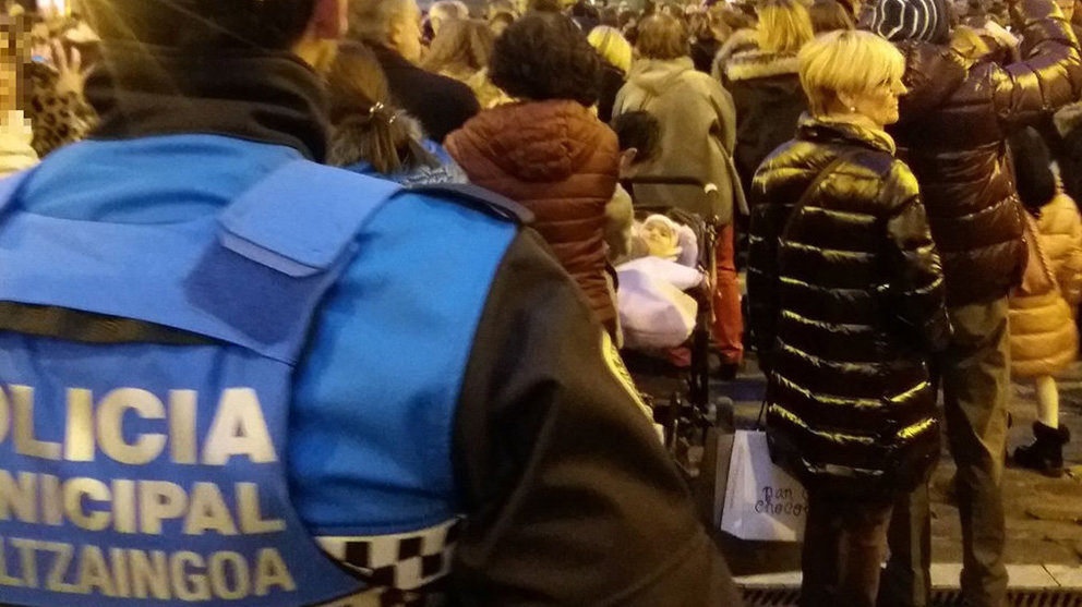 Un agente de la Policía Municipal de Pamplona realiza labores de vigilancia en una calle de Pamplona con aglomeración de vecinos ante un acto de Navidad. POLICÍA MUNICIPAL