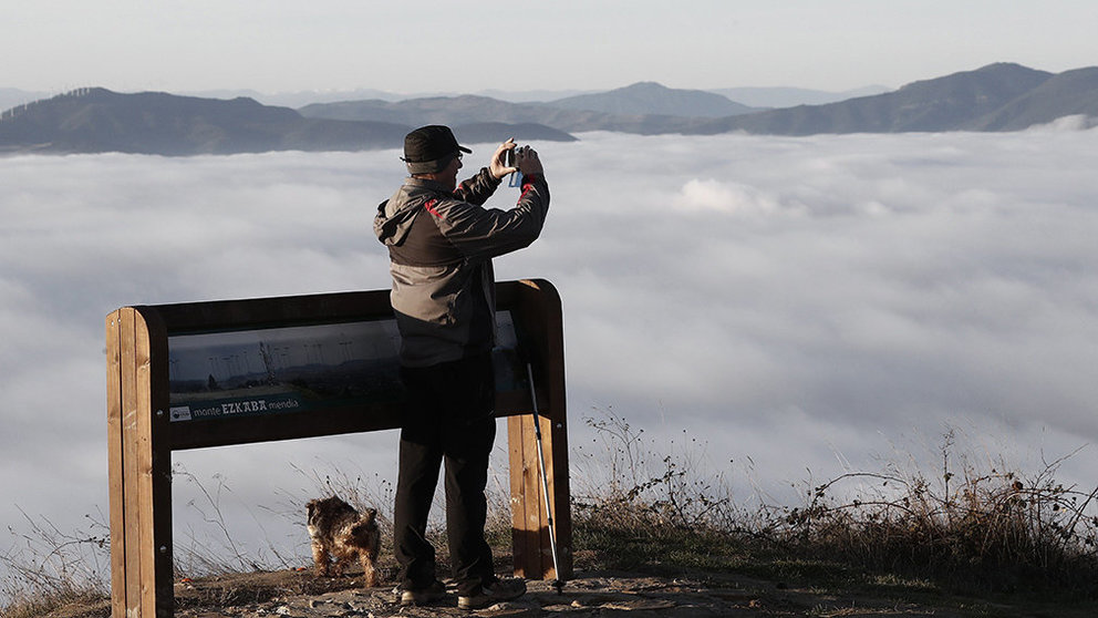 Una persona saca fotos con su móvil del amanecer en un día marcado por el tiempo de nieblas en la cuenca de Pamplona. EFE/Jesús Diges