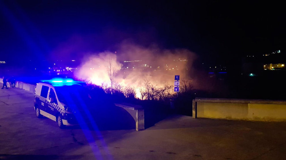 Una patrulla atiende el incendio de unos matorrales tras haberse lanzado varios petardos y cohetes. POLICÍA MUNICIPAL DE PAMPLONA