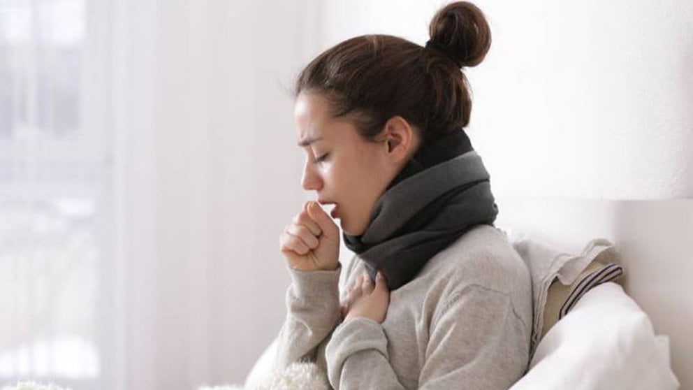 Imagen de una mujer joven tosiendo enferma en su cama ARCHIVO