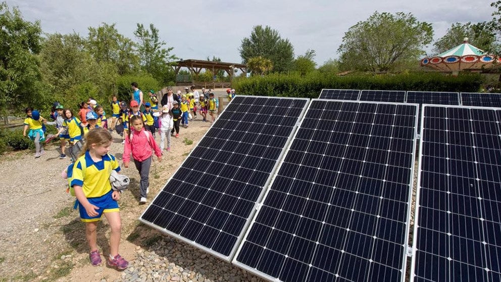 Varios niños de un colegio se acercan a una placa solar SENDAVIVA