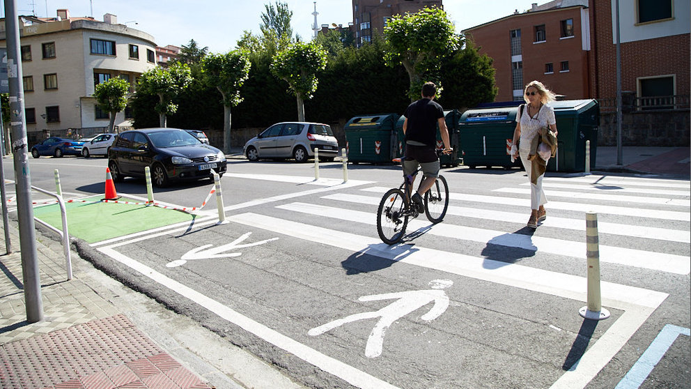 Un peatón y un ciclista cruzan un paso de peatones en la calle Aoiz de Pamplona. ÍÑIGO ALZUGARAY
