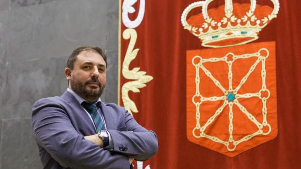 Unai Hualde, del PNV, posa junto a la bandera de la Comunidad foral de Navarra en el Parlamento. PARLAMENTO DE NAVARRA