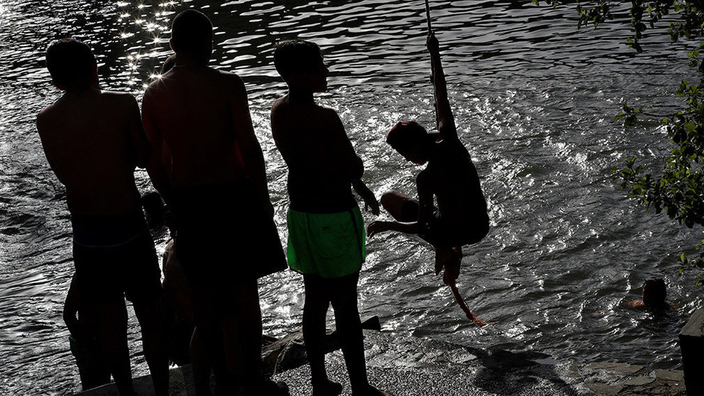 GRAF4778. PAMPLONA, 26/06/2019.- Varios jóvenes combaten el calor este miércoles en el río Arga a su paso por Pamplona donde las altas temperaturas extremas continuarán hasta el próximo lunes. EFE/Villar López