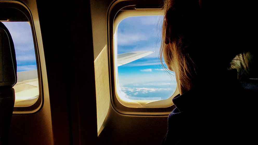 Una mujer mira por la ventanilla del avión durante un vuelo. ARCHIVO