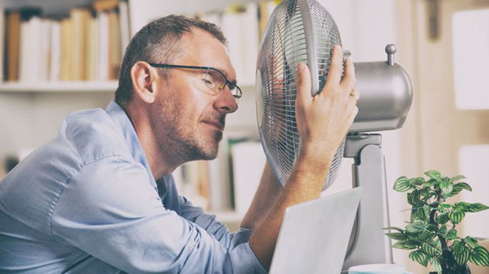 Imagen de un hombre abrazado a un ventilador para así superar el calor ARCHIVO