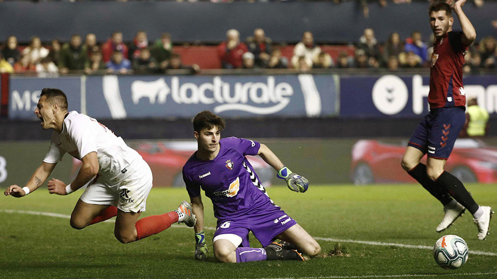 El delantero del Sevilla &#34;Chicharito&#34; Hernández (i) cae ante el portero Juan Pérez (c), de Osasuna, durante el partido de Liga en Primera División disputado este noche en el estadio de El Sadar, en Pamplona. EFE/Jesús Diges.
