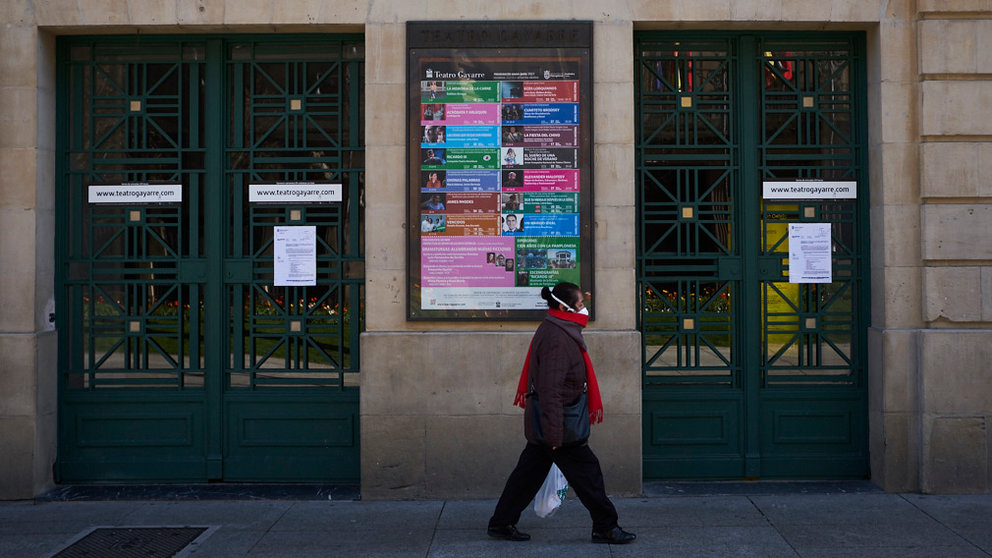 Una mujer camina por la puerta de un teatro de Pamplona con una mascarilla puesta. PABLO LASAOSA