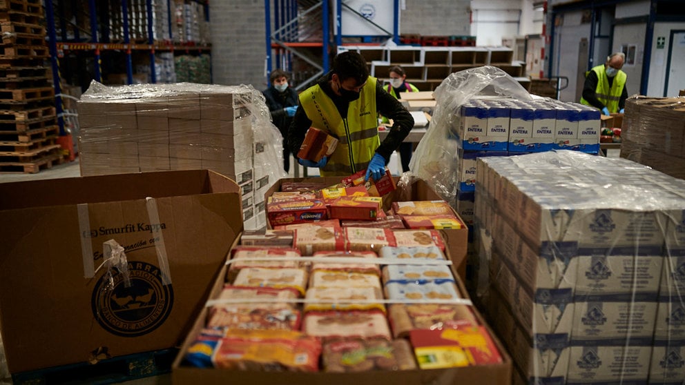 Voluntarios de Banco de Alimentos de Navarra y de ASVONA empaquetan comida en cajas para llevarlas a las casas de personas con necesidad durante la crisis del coronavirus. PABLO LASAOSA
