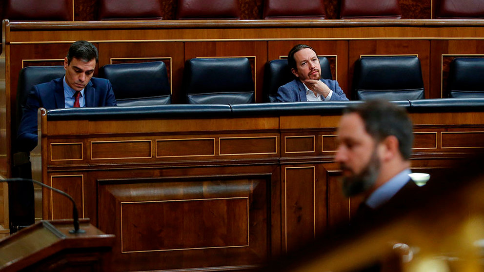 Spanish Prime Minister, Pedro Sanchez (L), chats with Second Deputy Prime Minister, Pablo Iglesias (R), look at far-right Vox party's leader Santiago Abascal (R) as he is in his way to deliver a speech during the plenary session at Lower Chamber of Spanish Parliament, in Madrid, Spain, 09 April 2020. The session is to be focused in passing a new extension of the state of alarm due to coronavirus outbreak. EFE/Mariscal POOL
