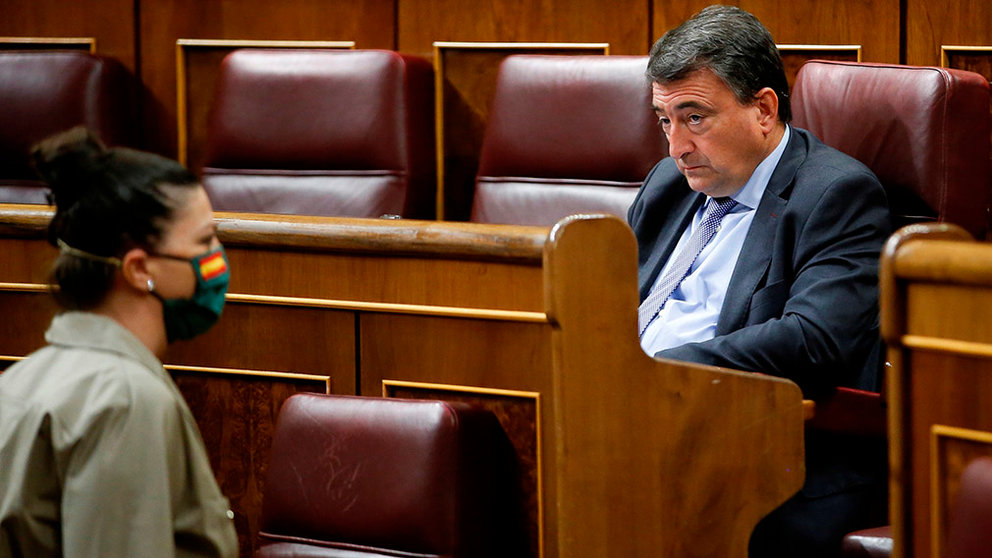 Basque Nationalist Party's parliamentary spokesman, Aitor Esteban (R), looks at far-right Vox party's MP Macarena Olona (L), wearing a mask with Spanish flag, during the plenary session at Lower Chamber of Spanish Parliament, in Madrid, Spain, 09 April 2020. The session is to be focused in passing a new extension of the state of alarm due to coronavirus outbreak. EFE/Mariscal POOL
