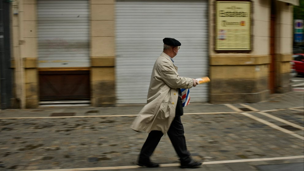 Una persona camina con una barra de pan por la calle Estafeta de Pamplona durante la crisis del coronavitus. PABLO LASAOSA