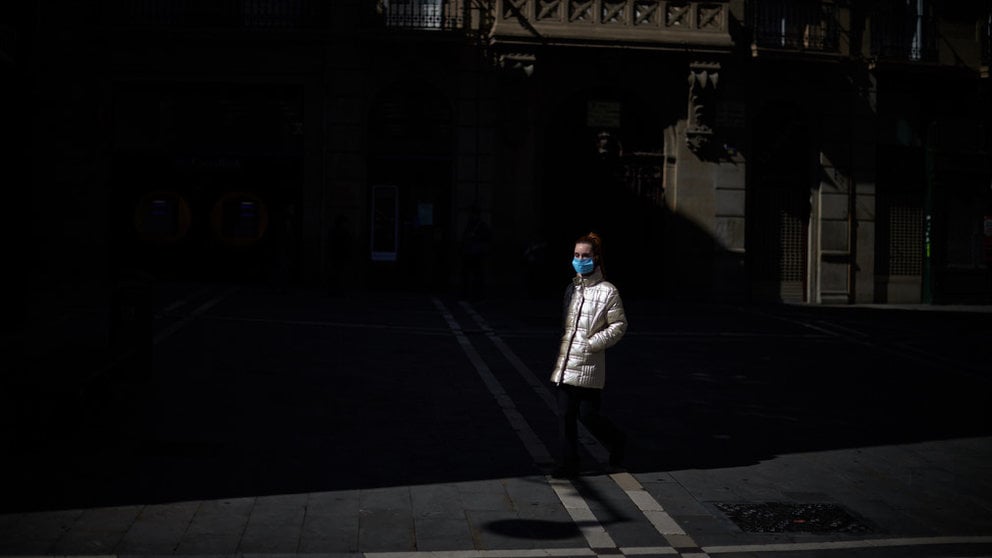 Una mujer con mascarilla pasea por la plaza del ayuntamiento durante la crisis por coronavirus en Pamplona. Miguel Osés