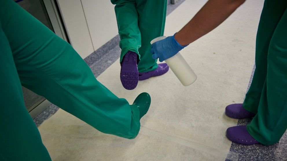 Una enfermera desinfecta los zuecos de otras dos, tras estar en un box con una persona con coronavirus. PABLO LASAOSA