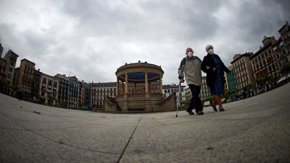 Un matrimonio con mascarilla camina por la Plaza del Castillo durante la crisis del coronavirus en Pamplona. Miguel Osés