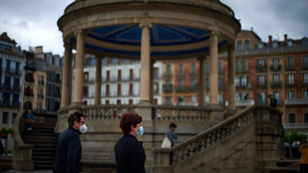Un hombre y una mujer con mascarilla caminan por la Plaza del Castillo durante la crisis del coronavirus en Pamplona. Miguel Osés