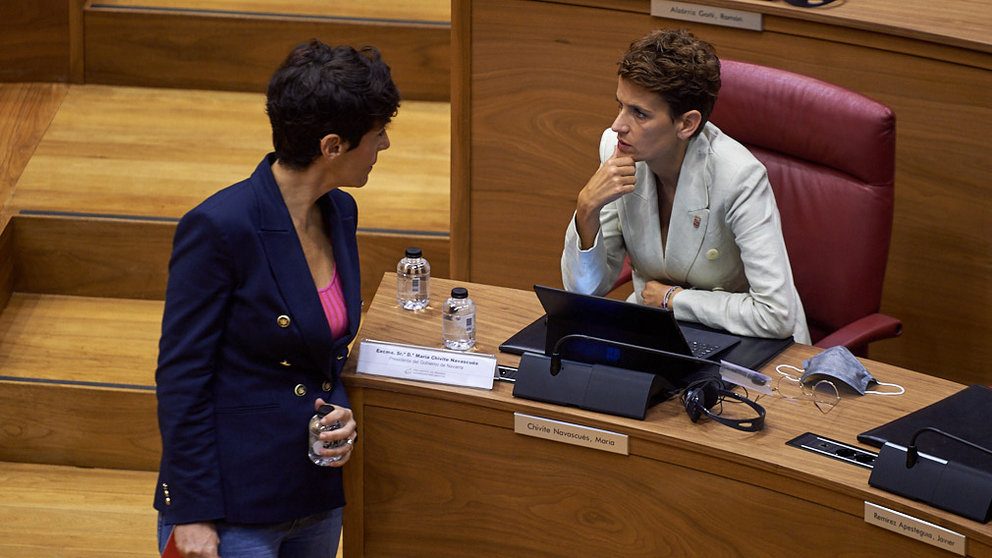 La presidenta del gobierno de Navarra habla con Inma Saiz, consejera de Hacienda, en el Pleno del Parlamento. MIGUEL OSÉS