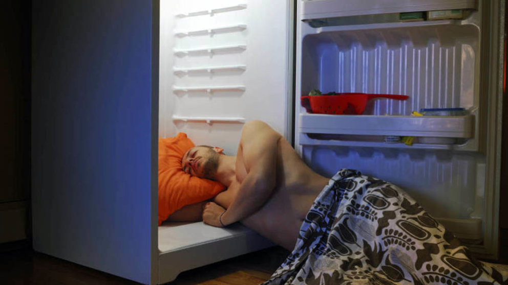 Una persona duerme con medio cuerpo dentro del frigorífico en una noche de mucho calor. ARCHIVO.