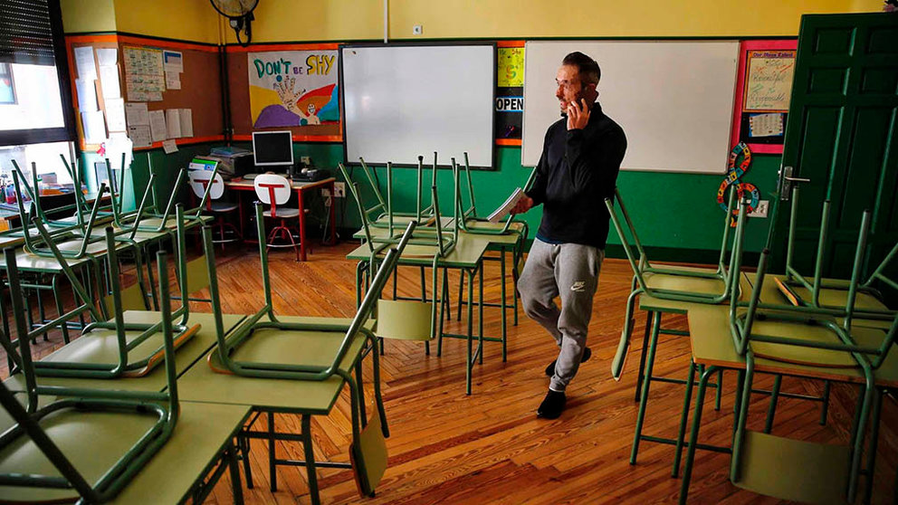 Un docente habla por su teléfono móvil en un aula desierta en el colegio público Rufino Blanco en Madrid. EFE/ Paco Campos/Archivo
